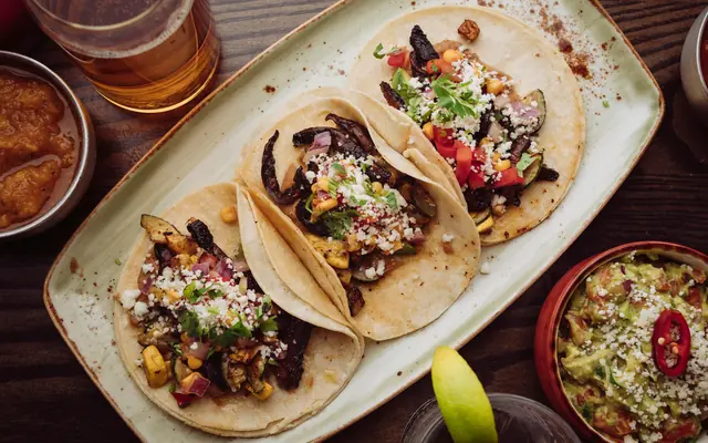 Tacos, salsa och lime på ett mörkt bord